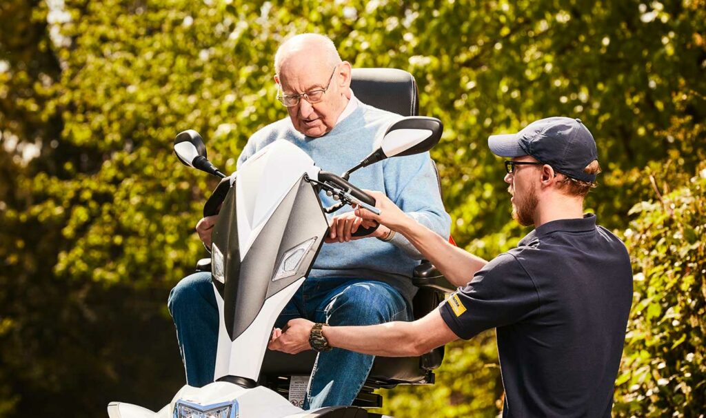 Ein Mitarbeiter von Mitschke weist einen Kunden in die Nutzung seines Elektromobils ein.