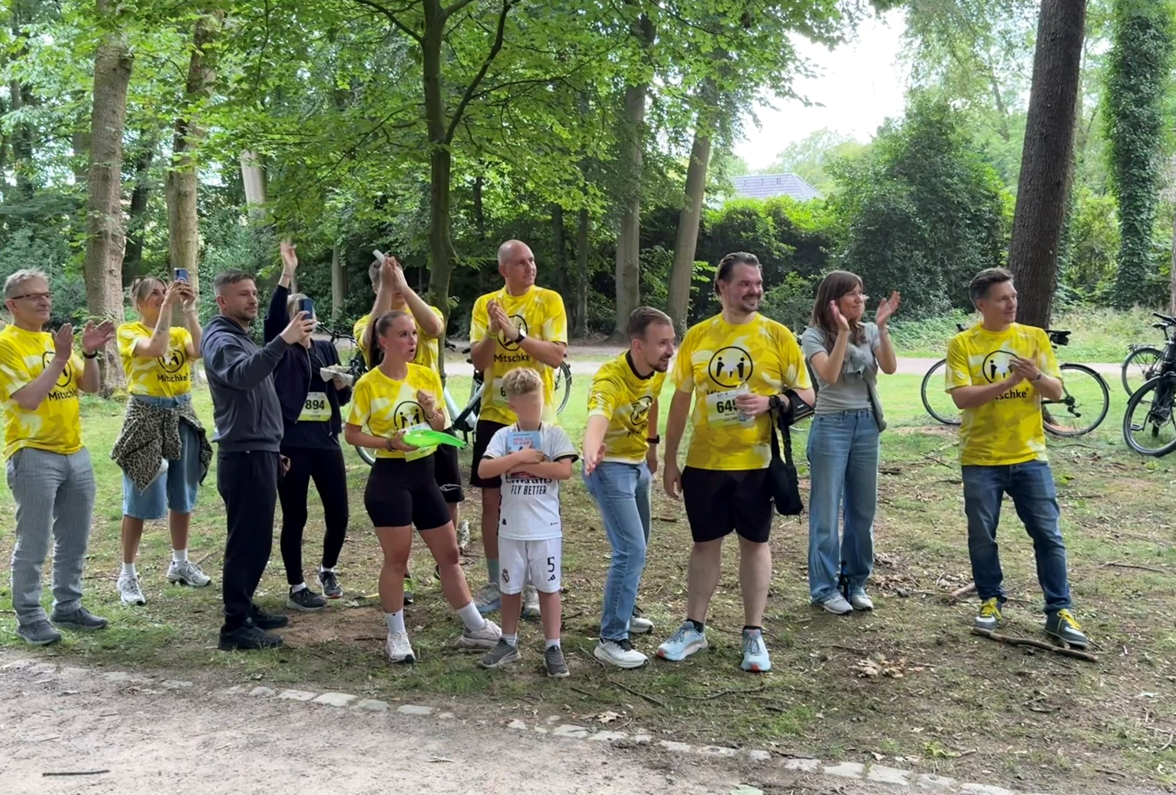 Mitschke MItarbeitende in gelben Trikots am Rand der Lauftstrecke von GT läuft 2026 jubeln und klatschen