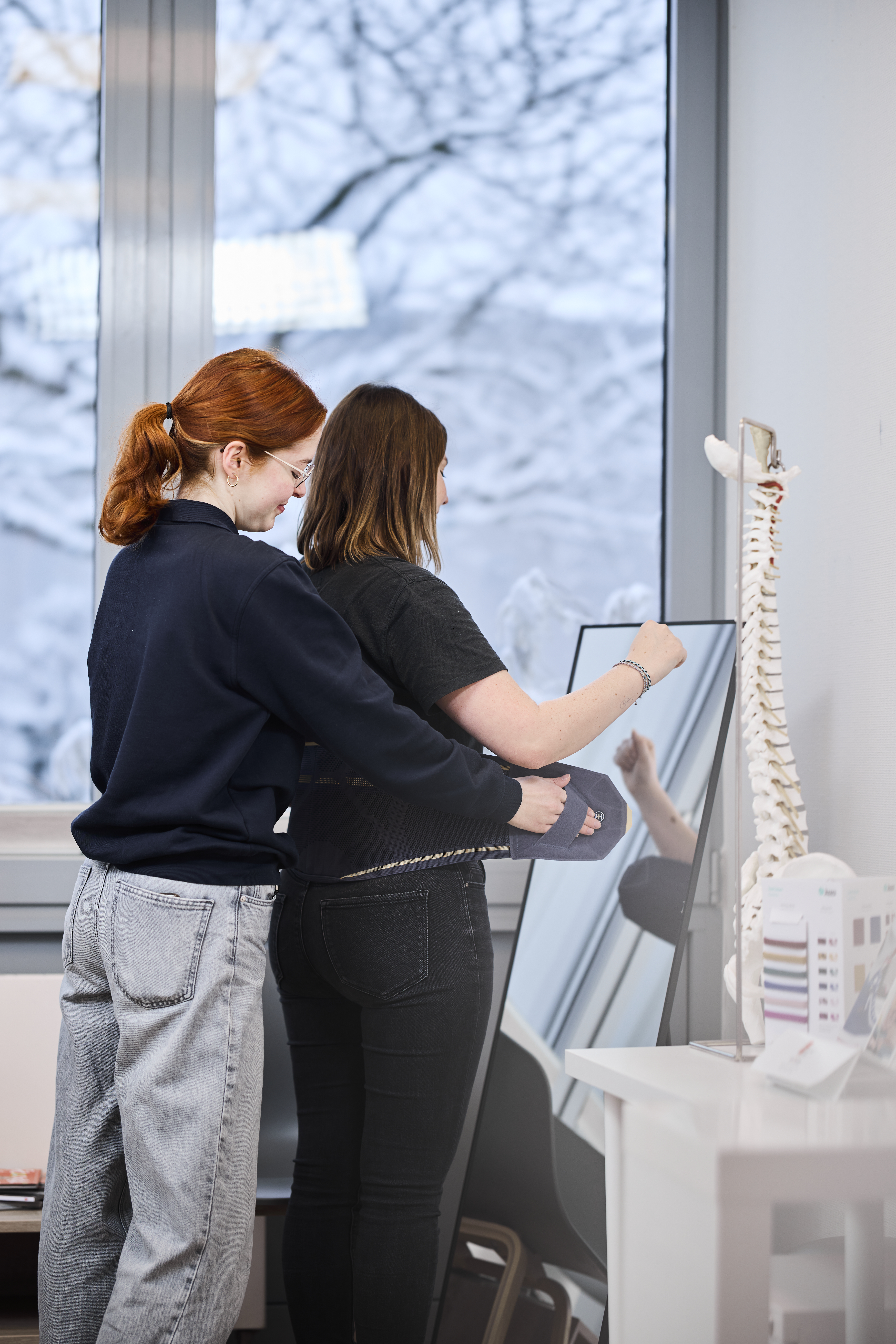 Junge Orthopädietechnikerin bereitet Kundin für Körperstatikanalyse vor